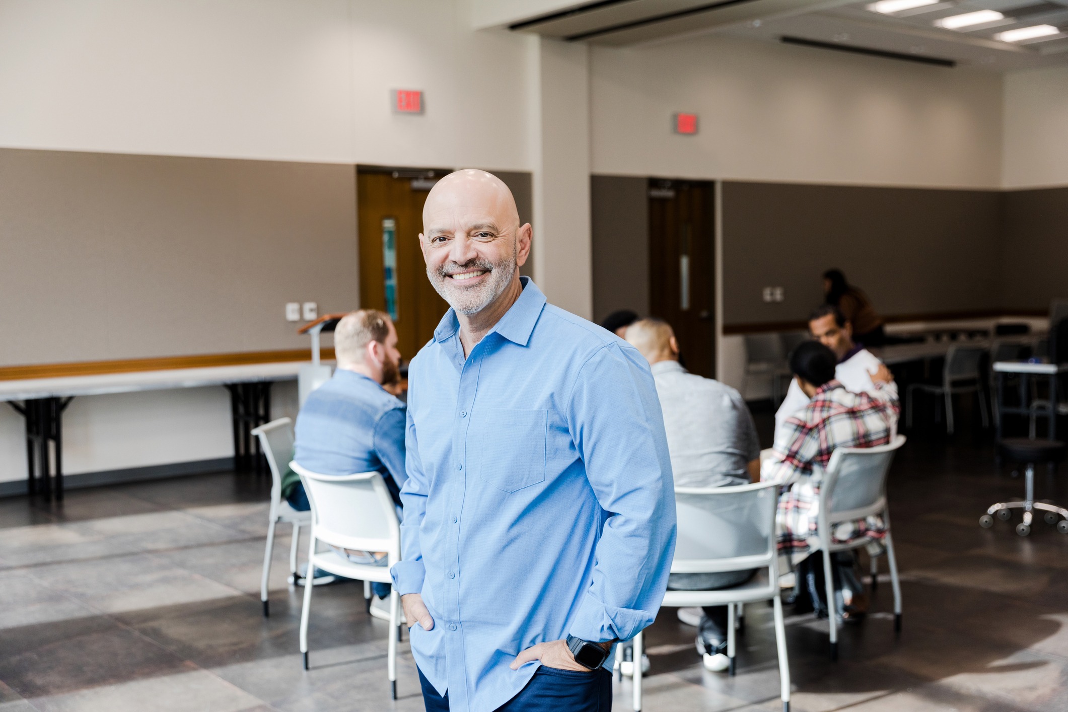 Smiling counselor taking a moment away from group counseling, inviting others to reach out for guidance and support in their mental health journey